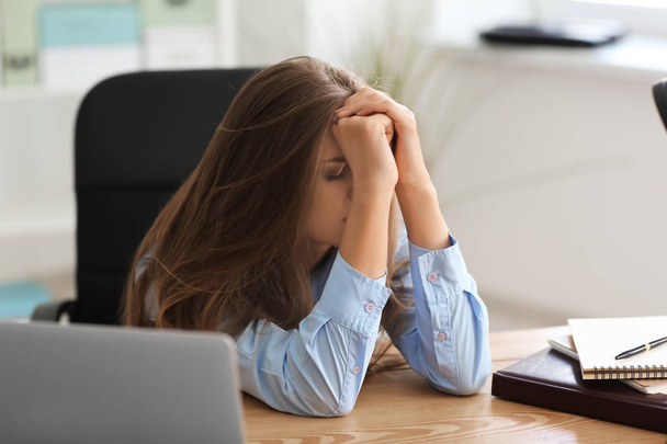 Расстроенная молодая женщина в офисе - Фото, изображение