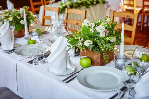Simple and elegant table for a festive or wedding event, decorated in green and white. - Фото, изображение