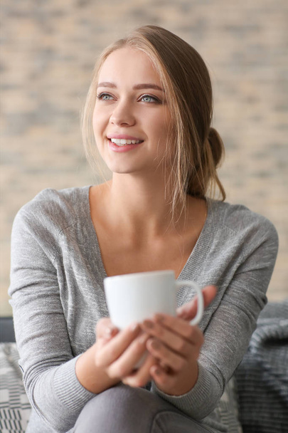 Szczęśliwa młoda kobieta picia herbaty w domu - Zdjęcie, obraz