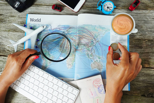 Поиск авиабилетов онлайн с женщиной ищет пункт назначения на карте в окружении туристических объектов
 - Фото, изображение