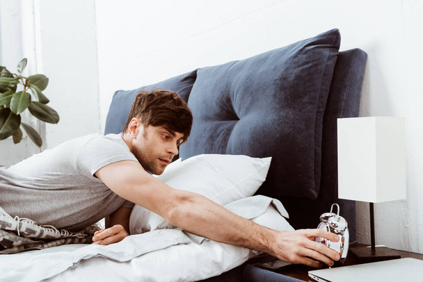 szelektív összpontosít, fiatal férfi az ágyban otthon ébresztő kikapcsolása - Fotó, kép