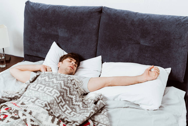 男の朝時に自宅のベッドでストレッチの選択と集中 - 写真・画像