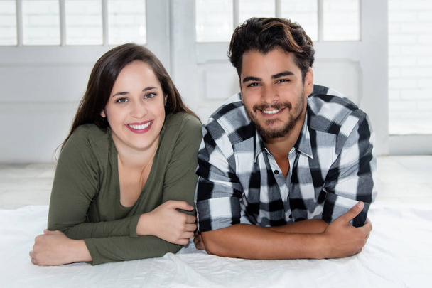 Caucasian woman with arab boyfriend looking at camera at home - Photo, image