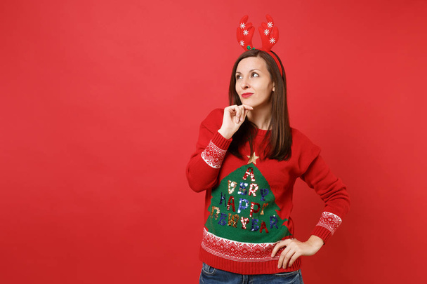 Eğlenceli dalgın Noel Baba kız bakılması, dekoratif geyik boynuzları giy el pervane parlak kırmızı zemin üzerine izole çene. Mutlu yeni yıl 2019 kutlama tatil parti kavramı. Kopyalama alanı alay - Fotoğraf, Görsel