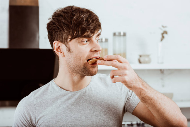 портрет человека, поедающего тосты с джемом на завтрак на кухне
 - Фото, изображение