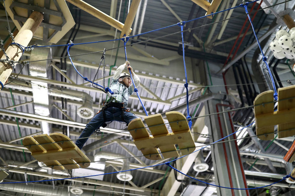 Boy climbing in the rope park indoor - Foto, Imagen
