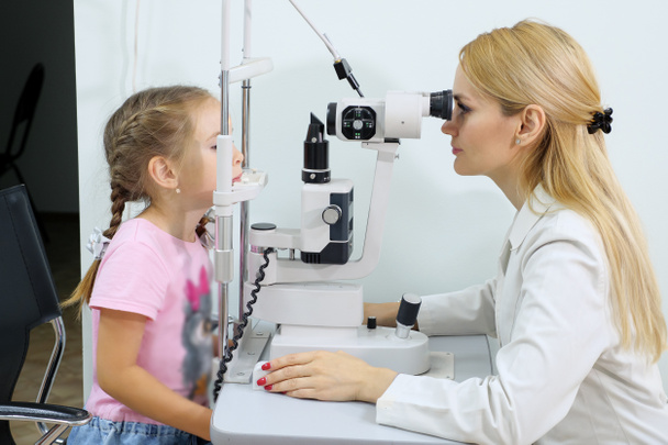 Οφθαλμίατρος εξετάζει το θέαμα της κοριτσάκι στο Οφθαλμιατρείο. - Φωτογραφία, εικόνα
