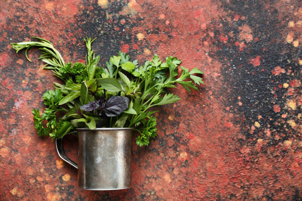 Copo de metal com ervas aromáticas frescas no fundo de cor
 - Foto, Imagem