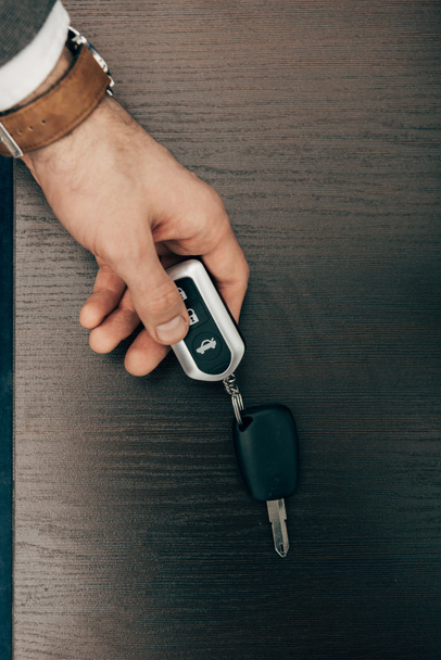 cropped image of businessman taking off remote car key from table  - Photo, Image
