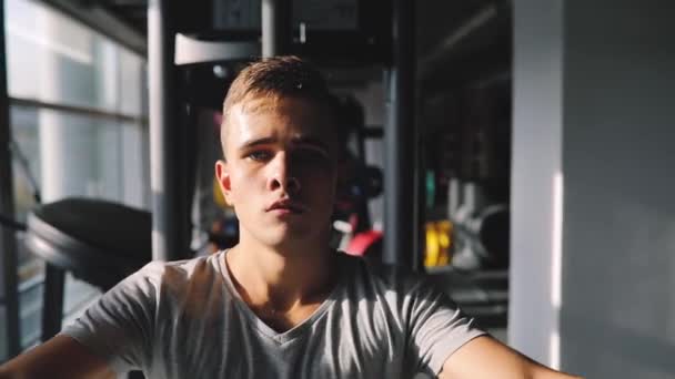 Young beginner man exercising in gym training with training apparatus - Záběry, video