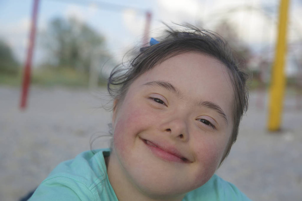 Portret van een lachend meisje met het syndroom van Down - Foto, afbeelding