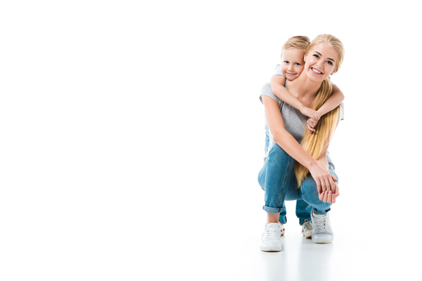 Little son hugging his beautiful mother and they looking at camera isolated on white - Valokuva, kuva