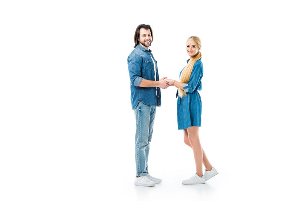 Pretty couple holding hands and looking at camera isolated on white - Fotoğraf, Görsel