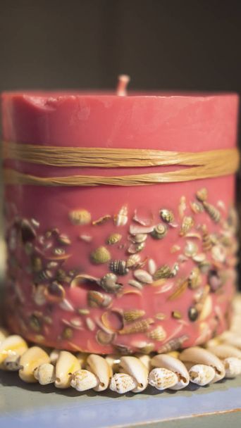 Close-up shot van koraal-gekleurde kaars vervaardigd met mariene elementen. Badkamer en Wellness inrichting met ontspanning en aromatherapie kaarsen. - Foto, afbeelding