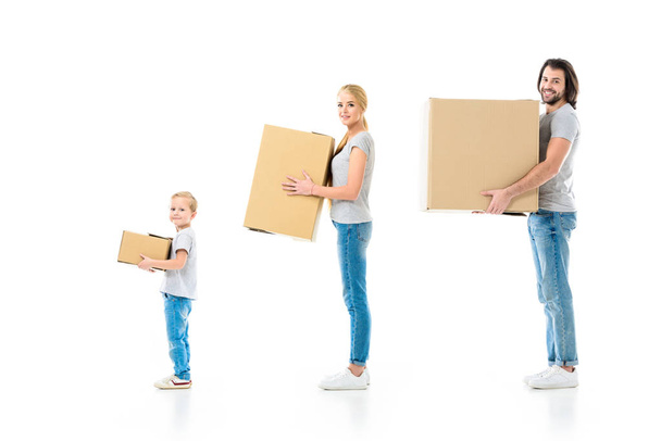 Happy family holding boxes and looking at camera isolated on white - Fotografie, Obrázek