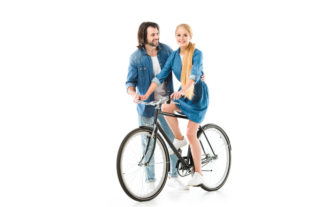 Blonde girl riding bicycle and man helping her isolated on white - Valokuva, kuva