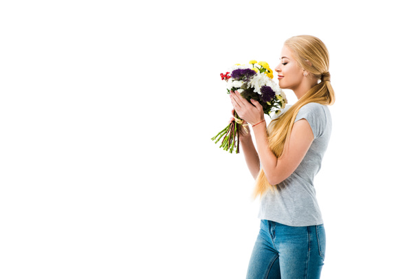 Beautiful girl smelling bouquet of flowers isolated on white - Foto, afbeelding