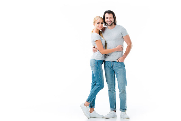  beautiful couple wearing jeans and grey T-shirt hugging each other isolated on white - Фото, изображение