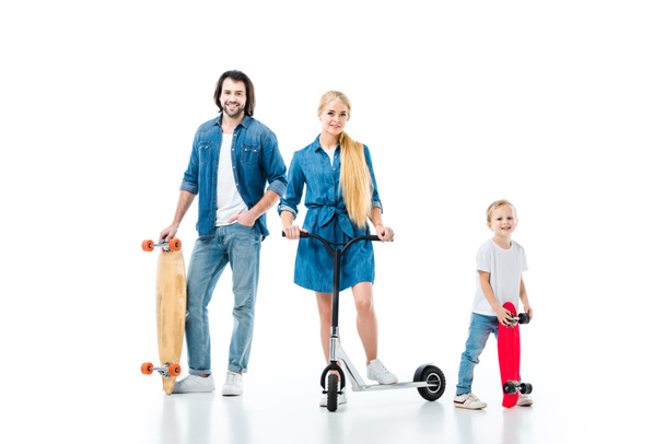 Happy family having fun with scooter and skateboards isolated on white - Photo, Image