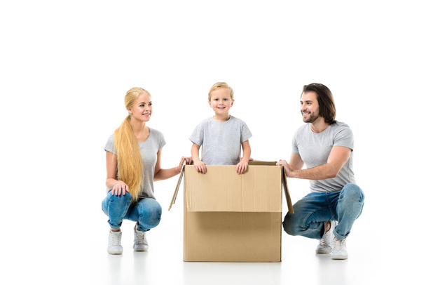 Boldog család-val egy nagy mozgó papír doboz elszigetelt fehér kis fia - Fotó, kép