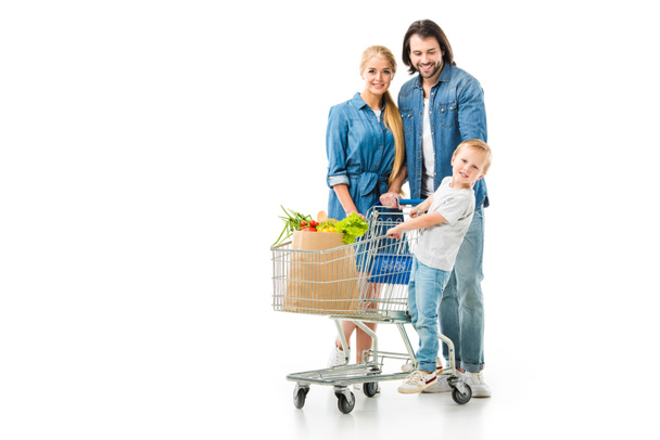 Happy family with shopping cart and grocery bag full of healthy food isolated on white - Φωτογραφία, εικόνα