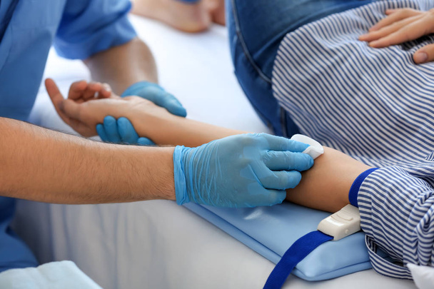 Krankenschwester bereitet Spenderin auf Bluttransfusion im Krankenhaus vor - Foto, Bild