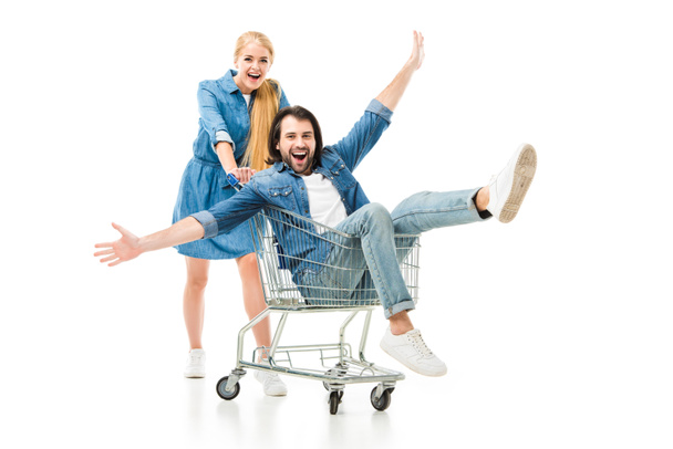 excited couple laughing and having fun with shopping cart isolated on white  - Photo, Image
