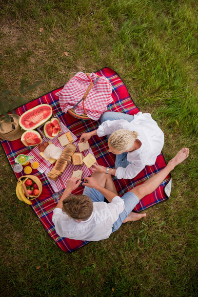 Couple in love enjoying picnic time drink and food in beautiful nature on the river bank top view - Valokuva, kuva