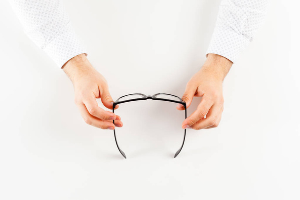 Glasses in hands at white background. - Photo, Image