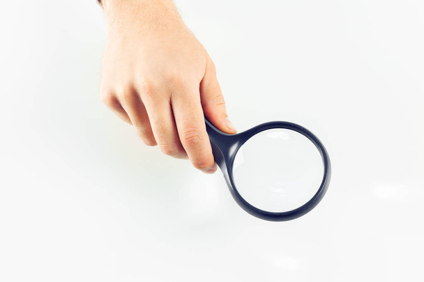 Hand with magnifying glass on white background - Φωτογραφία, εικόνα