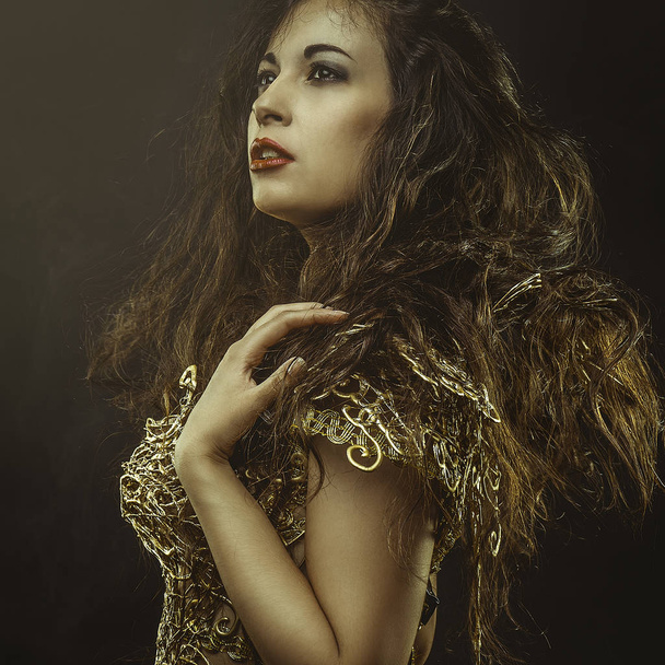 Glance, beautiful brunette woman with long brown hair dressed in gold suit, sensual and elegant poses - Photo, Image