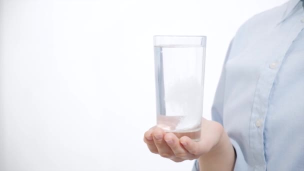 Fille tenant un verre d'eau avec le médicament. Fond blanc
 - Séquence, vidéo