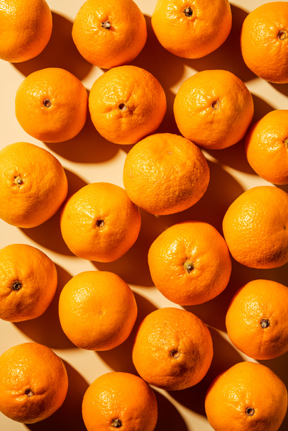 Top view of arranged fresh wholesome tangerines on beige background - 写真・画像