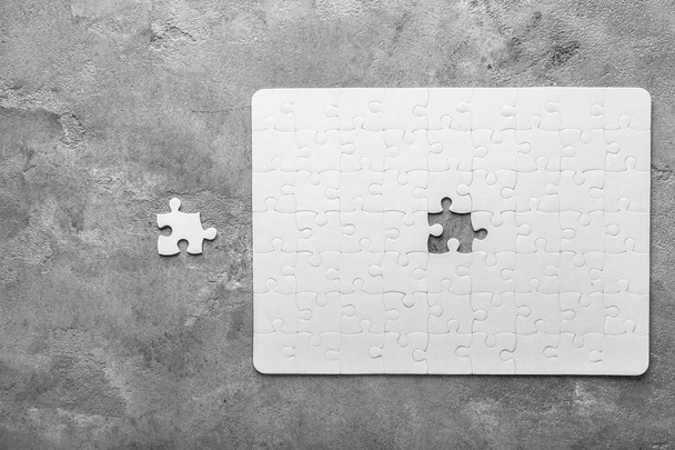 Witte puzzel met stuk op grijze achtergrond - Foto, afbeelding