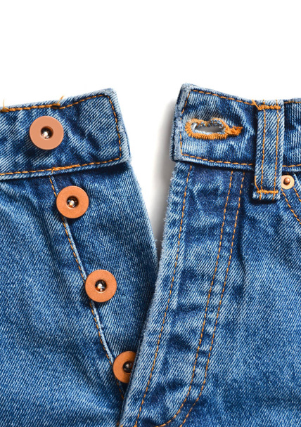 Pantalones vaqueros azules desabotonados con botones de metal sobre un fondo blanco. Espacio para texto
. - Foto, imagen