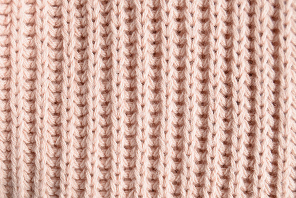 die Textur eines rosafarbenen Strickpullis in Nahaufnahme. Ansicht von oben. Textilbekleidung. - Foto, Bild