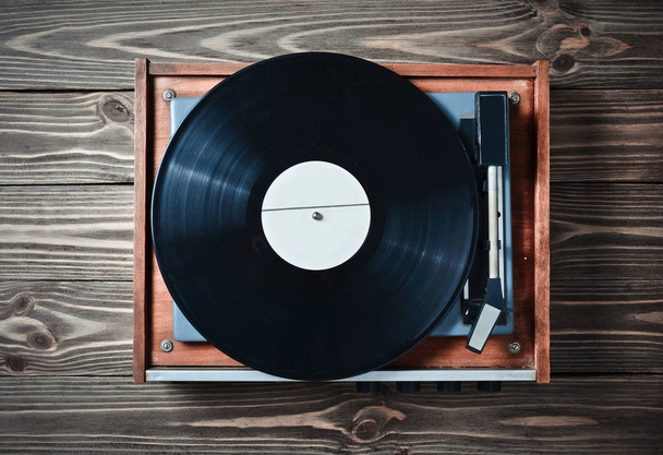 Lecteur en vinyle avec assiettes sur une table en bois. Divertissement années 70. Écoutez de la musique. Vue du dessus
. - Photo, image