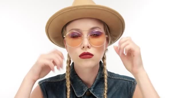 models in hat with two braids and glassess, looks like a cowboy girl - Materiał filmowy, wideo