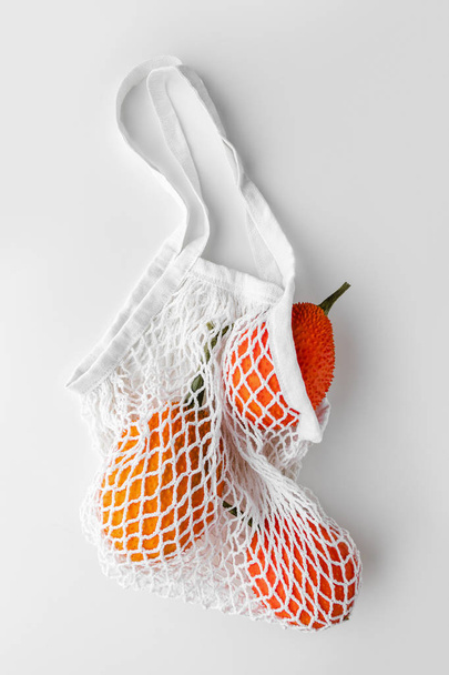 Gac fruta sobre un fondo blanco, creativo concepto de comida laica plana
 - Foto, imagen