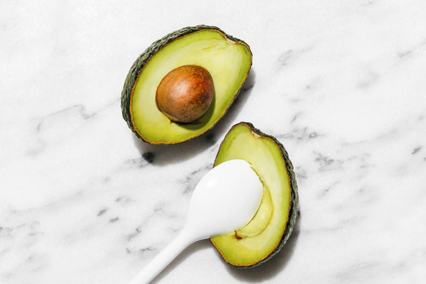 Свіжі органічні авокадо на білому мармуровому тлі, креативна квартира закладає концепцію здорової їжі
 - Фото, зображення
