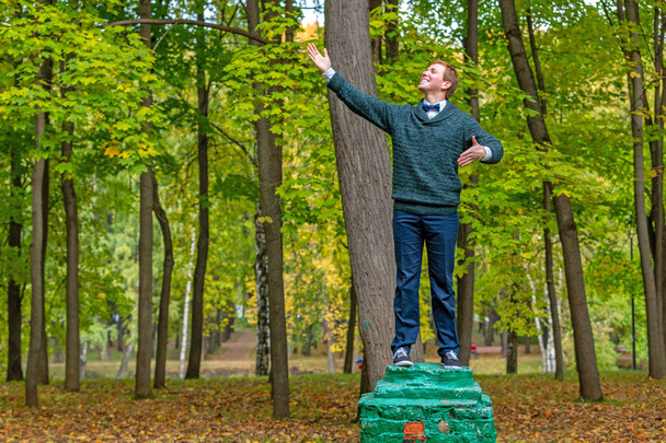 Un homme sur un piédestal qui prétend être une statue dans le parc d'automne
. - Photo, image