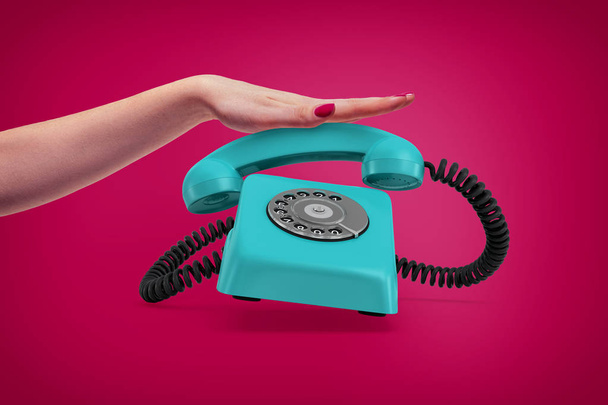 An elegant female hand presses down a handle of a retro blue rotary phone that rings and almost jumps up. - Φωτογραφία, εικόνα