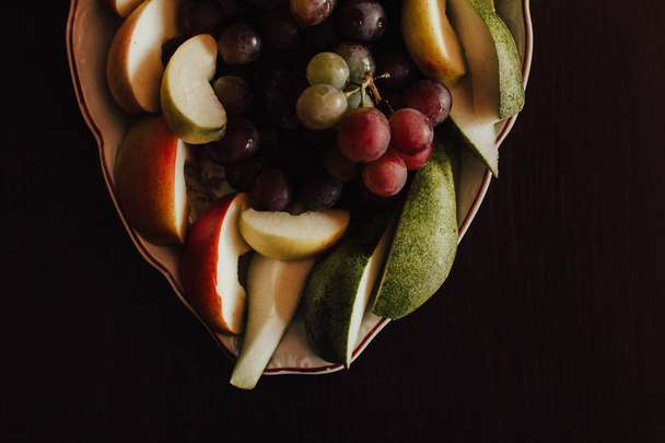 Plate of grapes and sliced apple and pears - Foto, afbeelding
