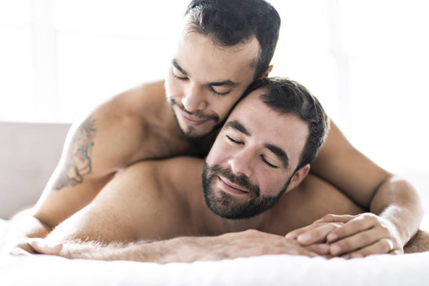 A Handsome gay men couple on bed together - 写真・画像