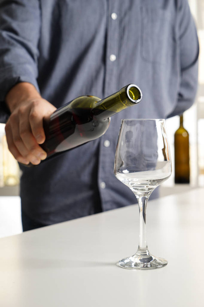 Barman pouring tasty wine in glass at party - Foto, imagen