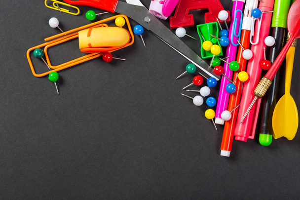 Different colorful stationery on black background - Foto, imagen