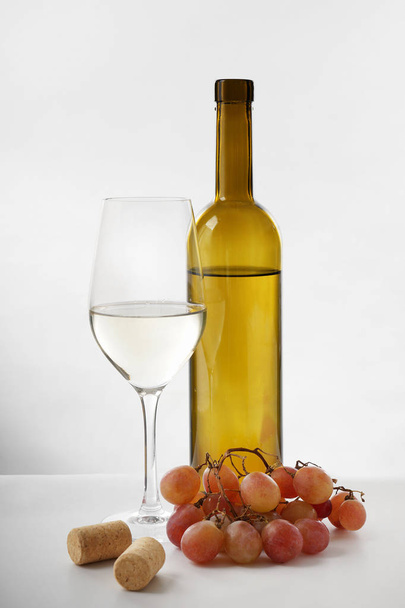 Tasty wine and grapes on white background - Photo, Image