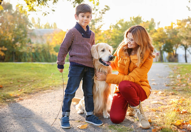 Mother with son and their dog in autumn park - Photo, Image