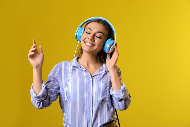 Beautiful woman listening to music on color background - Photo, Image