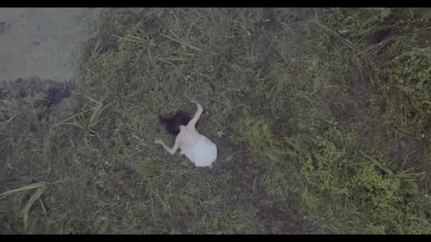 Aerial tiro jovem menina em vestido branco correndo em um campo gramado no nevoeiro
 - Filmagem, Vídeo